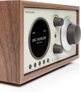 Radio Tivoli Model One+ i valnød og beige front, sort rundt display, stor volumenknap, knapper 1–5, 3/4 venstre sidevisning