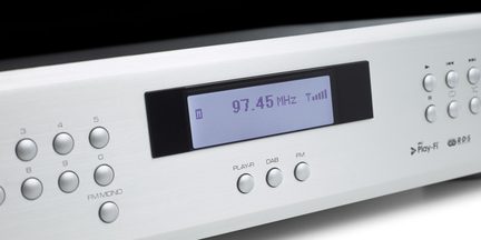 Digitalni zaslon, ki prikazuje "97,45 MHz Tarif" na sivi elektronski napravi z gumbi in vrtljivim gumbom