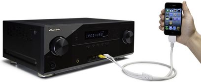 Zwarte Pioneer VSX-921-K home cinema-versterker, vooraanzicht, aangesloten op een witte iPhone via een kabel, licht van bovenaf gefotografeerd