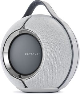 Бездротова колонка DEVIALET MANIA світло-сірого кольору, вид спереду, сплющена сферична форма, сіра металева решітка, центральний логотип