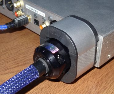 Furutech NCF Booster Brace Single i grå metal, blå konnektor, blå flettet kabel, set fra siden på et træbord
