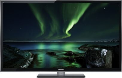 Bølgende grøn nordlys, der spejler sig i en rolig vandflade omgivet af mørke klipper på en tv-skærm