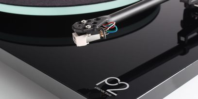 Rega Planar 2 sort lakeret pladespiller, nærbillede af tonearmen med pickup og farvede kabler, set fra siden