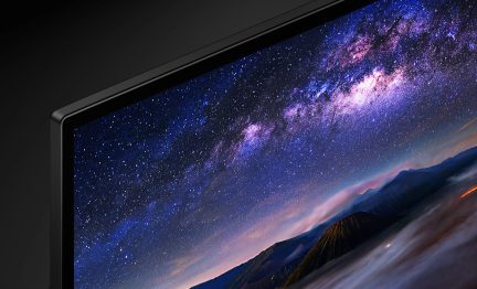 Tv-skærm, der viser et billede af Mælkevejen og bjerge, stjernehimmel i lilla og lyserøde farver