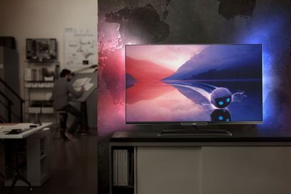 Philips 60PFL6008H-fladskærm tændt, der viser et blåt og rødt sølandskab, set forfra på et møbel i et mørkt rum