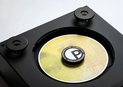 Sort Pro-Ject pladevægter på gul vinyl placeret på pladespiller set ovenfra￼