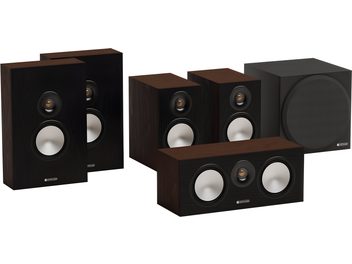 Háromnegyed elől nézet egy Monitor Audio Bronze 50 5.1 diószínű könyvespolc-hangfalrendszerről, sötét diófurnér borítású, fekete homlokzatú téglalap alakú dobozokkal, matt fehér woofer-kúpokkal és aranyozott kupolás tweeter-ekkel