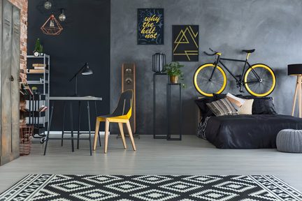Cassa acustica a colonna in legno marrone con finitura opaca, vista frontale, struttura rettangolare slanciata con pannello frontale nero dotato di due altoparlanti circolari grigi e condotto bass reflex rotondo in basso