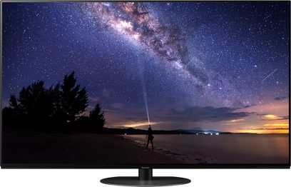 Panasonic TX-55LZ1000E-fladskærm, der viser et natligt stjernelandskab med en person på en strand i forgrunden