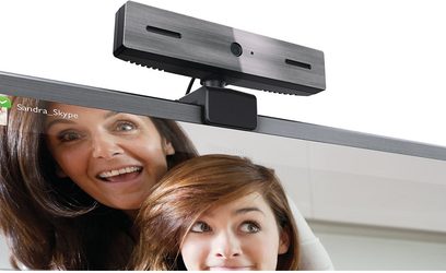 Philips PTA317 webcam set forfra, sort, monteret på en computerskærm, med en smilende kvinde og en lille pige