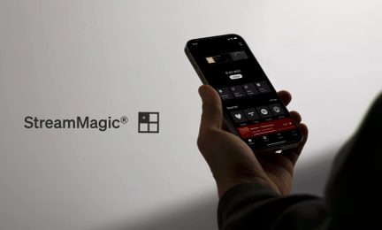 App StreamMagic su smartphone nero tenuto in mano, schermata di controllo audio e logo a sinistra