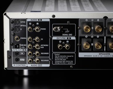 Denon PMA-1700NE sølv hi-fi stereoanlegg, nærbilde forfra av bakpanelet med audio-kontakter og høyttalertilkoblinger