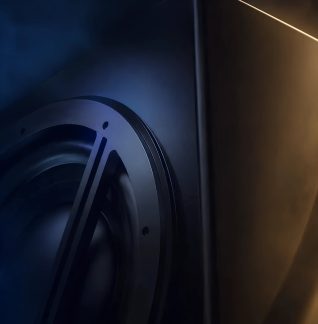 Close-up de um alto-falante preto com woofer circular em caixa de som de coluna com design moderno