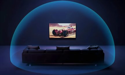 Vægmonteret tv over en sort sofa, skærm med rød racerbil i en mørkeblå stue