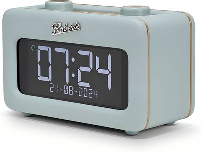 Radio-vækkerur Roberts Revival Rest i himmelblåt kunstlæder, set fra tre kvart forfra, med stort digitalt sort display med hvide tal, tynde gyldne kanter og to cirkulære drejeknapper på toppen