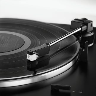 Sort Audio-Technica pladespiller i close-up med sølvfarvet tonearm på sort plade