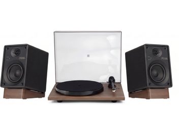 Crosley-vinylspelare med transparent lock och två svarta högtalare på stativ med träfinish