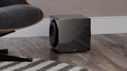Musta läikiva kuubikukujulise korpusega SVS subwoofer külgmise valjuhääldiga elutoa parketil