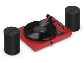 Röd vinylspelare med svart skiva, tonarm och två svarta trådlösa Sonos-högtalare