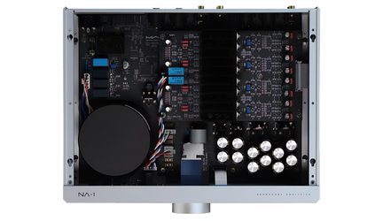 Avattu Matrix Audio NA-1 -kuulokevahvistin, sisänäkymä, jossa suuri muuntaja ja hopeanväriset kondensaattorit
