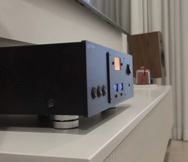 Sort TAGA Harmony hi-fi-forstærker med baggrundsbelyst VU-meter og frontbetjening, set fra trekvart vinkel