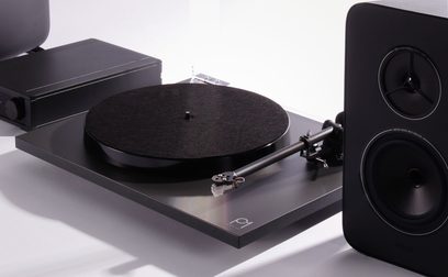 Rega System One hifi lemezjátszó fekete lemeztálcával, lemezfejjel, téglalap alakú erősítővel és két hangszórós hangszóróval