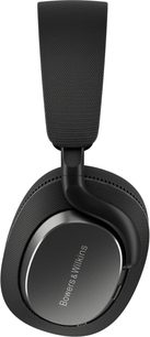 Bowers & Wilkins Px7 S3 Kopfhörer in mattem Schwarz, seitliche Nahaufnahme einer ovalen Ohrmuschel mit dunkler Metallplatte und Stoffpolster, gepolsterter Kopfbügel mit schwarzem Stoffbezug, verbunden durch ein schwarzes Kunststoffgelenk