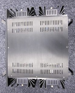 Rektangulært perforeret metalpladedesign med geometriske udskæringer, monteret på en metalstøtte med trekantede finner