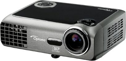Optoma EX330e videoprojektor i mørkegrå og sølvfarve, set forfra i let nedadgående vinkel, linse til højre, gitre og knapper til venstre