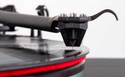 Célula cápsula para tocadiscos de vinilo Rega Ania Pro MC negra, primer plano de perfil del brazo de lectura, enfocada en la punta de lectura roja