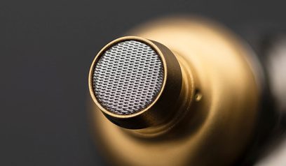 Gylden, cirkulær metalrist i nærbillede af Meze Audio ADVAR hovedtelefoner, set let skråt forfra