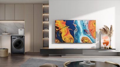 TCL 65QLED760 2022 TV i en moderne stue, der viser et farverigt abstrakt maleri i gule og blå nuancer