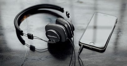 Sluchátka Bowers & Wilkins P3 S2 černá, s koženým obloukem a náušníky, kabel s jack konektorem, položená na texturovaném šedém povrchu