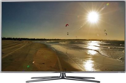 Samsung UE55D7000 TV der viser en øde strand ved solnedgang, glat sand, roligt hav, kitesurfere