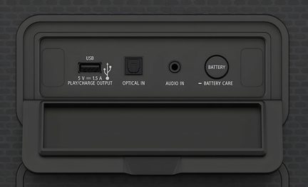 Vista frontale ravvicinata di un pannello posteriore in plastica nera opaca di un apparecchio audio, con porta USB di tipo A, ingresso ottico quadrato, jack da 3,5 mm, pulsante circolare Battery e dicitura Battery Care