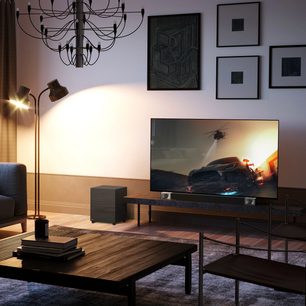 Moderne stue med loftlampe, sofa, træbordplade, fladskærms-tv der viser en bil og Klipsch Cinema 400 soundbar