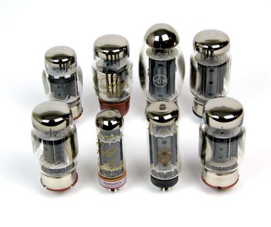 Set of eight cylindrical glass and metal vacuum tubes with chrome caps and exposed pins, top-down view