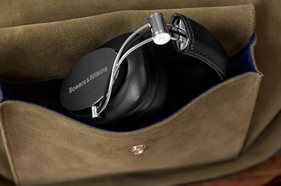 Sluchátka Bowers & Wilkins P7 Wireless v černé barvě, položená v béžovém látkovém pouzdře, pohled ze tří čtvrtin zepředu