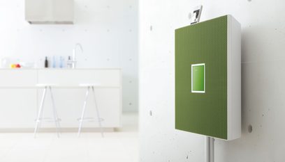 Zelený multimediální reproduktor Yamaha RESTIO ISX-800, pohled zepředu, připevněný na bílé zdi, se zeleně rozsvíceným displejem