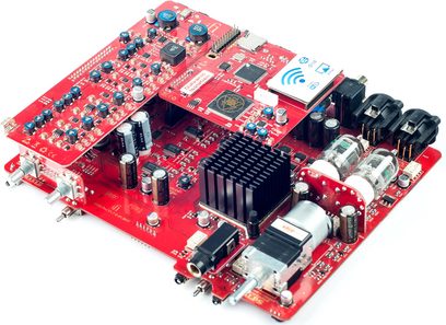 Rød printplade med elektroniske komponenter, audio- og USB-stik, potentiometre og kontakter