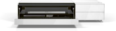 Lavt hvidt TV-møbel med åben skuffe, der viser en Sonos Blu-ray-afspiller, front med sort glas