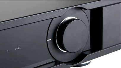 Botão rotativo de metal preto brilhante em um painel preto fosco, visto de frente em close-up
