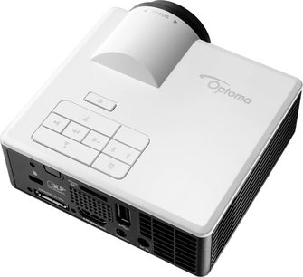 Optoma ML1050ST hvid projektor, set skråt oppefra og forfra til højre, kontrolknapper på toppen, tilslutningsporte på bagsiden