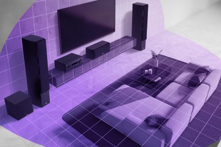 Svart hjemmekinoanlegg med veggmontert TV, gulvstående høyttalere, subwoofer og forsterker i en stue