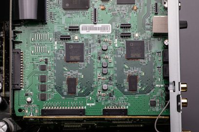 Carte électronique verte avec composants électroniques, puces, connecteurs et inscriptions techniques, vue rapprochée de face
