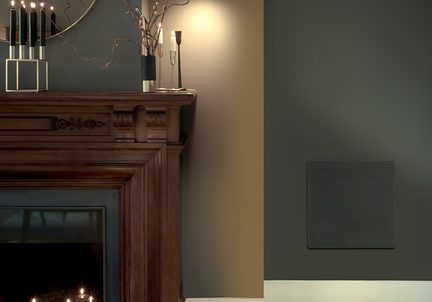 Interiør med mørk trepeis og lysestaker, grå vegg med beige stripe, svart veggpanel med avrundede hjørner, frontvisning