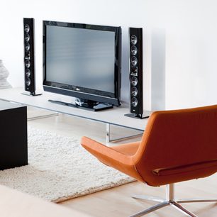 Sorte Klipsch Gallery G-28 gulvhøjtalere og fladskærms-tv placeret på hvidt tv-møbel i moderne stue