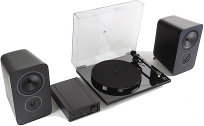 Rega System One hi-fi lemezjátszó átlátszó fedővel, két fekete hangszóróval és egy fekete téglalap alakú erősítővel