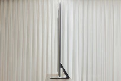Samsung QE85QN95B 2022 TV set fra siden, skærm slukket, på en hvid baggrund med lodrette striber