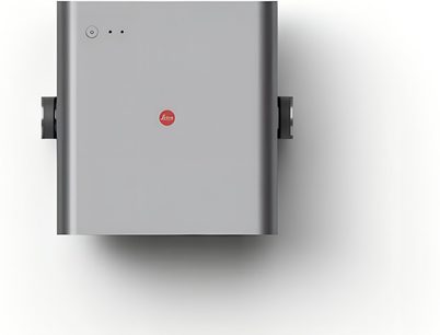 Leica Cine Play 1 -videoprojektori harmaata alumiinia ylhäältä kuvattuna, pelkistetty suorakulmainen muotoilu keskellä punainen logo